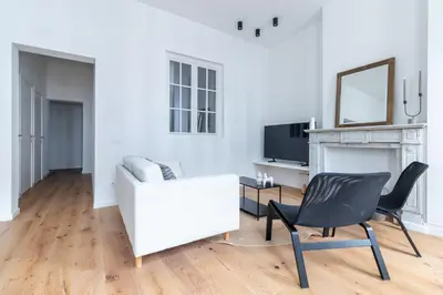 a living room with a white couch and a chair at Sleek City Stays - Urban Elegance in the Heart of Ghent in Ghent