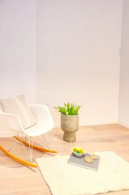 a living room with a white chair and a tray of food at 2-BR Getaway with MAS view in Antwerp