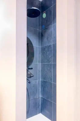 a bathroom with a shower with blue tiles at 2-BR Getaway with MAS view in Antwerp