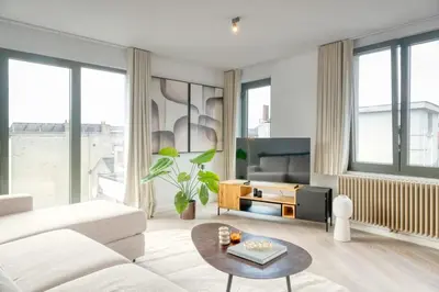 a living room with a white couch and a table at 2-BR Getaway with MAS view in Antwerp