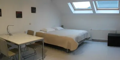 a bedroom with a bed and a table and a window at Aparthotel Midi Residence in Brussels