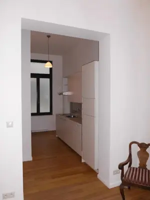 a kitchen with white walls and a chair in a room at Aparthotel Midi Residence in Brussels