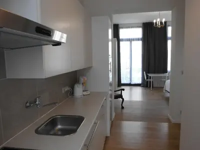 a kitchen with a sink and a living room at Aparthotel Midi Residence in Brussels