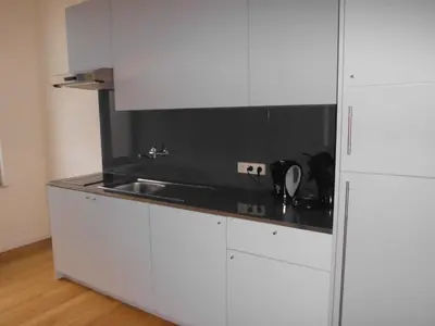 a kitchen with white cabinets and a black counter top at Aparthotel Midi Residence in Brussels