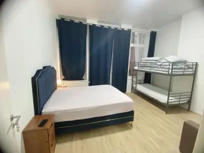 a bedroom with a bed and a bunk bed with blue curtains at Lux chamber in Brussels