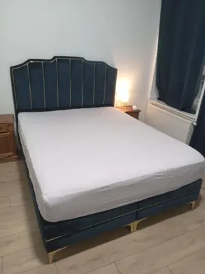 a bed with a black frame and white mattress at Lux chamber in Brussels