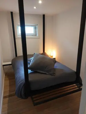 a bed with a black frame in a room at Huis-Chalet aan Puyenbroeck in Wachtebeke