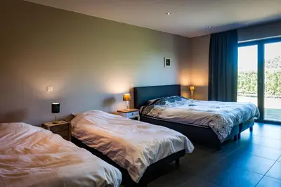 a hotel room with two beds and a window at Vakantiehoeve Berckelaer in Sint-Gillis-Waas
