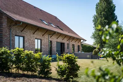 a brick house with a red roof at Vakantiehoeve Berckelaer in Sint-Gillis-Waas