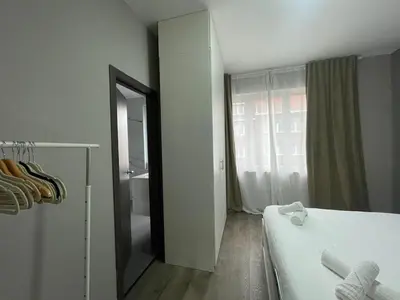 a bedroom with a bed and a mirror and a window at Cozy City Escape in Brussels