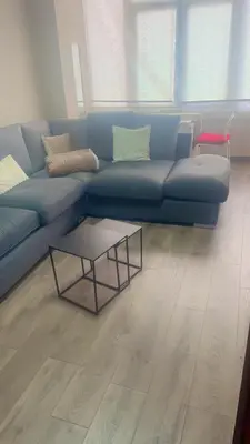 a blue couch in a living room with a table at Cozy City Escape in Brussels