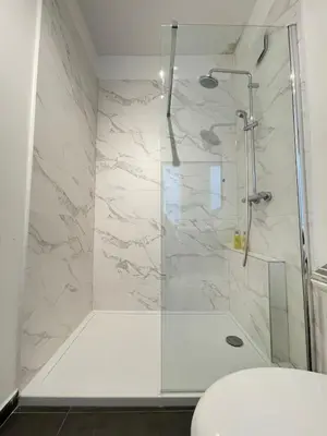 a shower with a glass door in a bathroom at COSY Duplex - EU DISTRICT in Brussels
