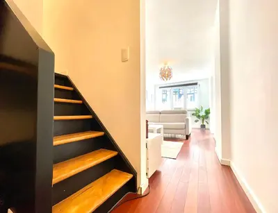 a staircase in a living room with wooden floors at COSY Duplex - EU DISTRICT in Brussels
