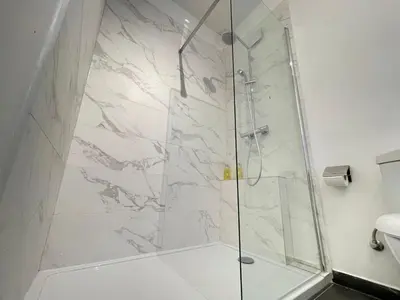a shower with a glass door in a bathroom at COSY Duplex - EU DISTRICT in Brussels