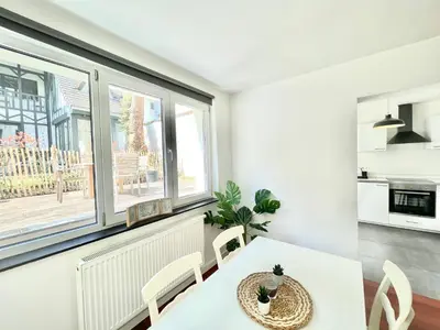 a dining room with a white table and chairs and a window at COSY Duplex - EU DISTRICT in Brussels