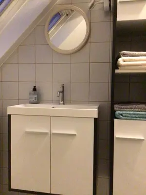 a bathroom with a sink and a mirror at Cosy attic apartment, terrace, 1 bedroom, double bed for 2 plus single bed if 3 guests in Buggenhout
