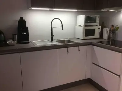 a kitchen with a sink and a microwave at Cosy attic apartment, terrace, 1 bedroom south, 1 double bed for 2, plus single bed if 3 guests in Opdorp