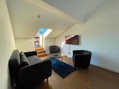 a living room with a couch and two chairs at La Perla Appartements in Brussels