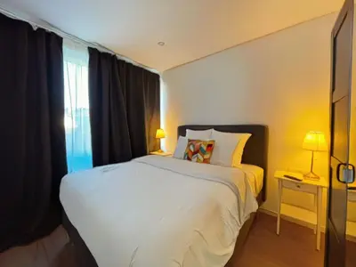 a bedroom with a white bed and a window at La Perla Appartements in Brussels