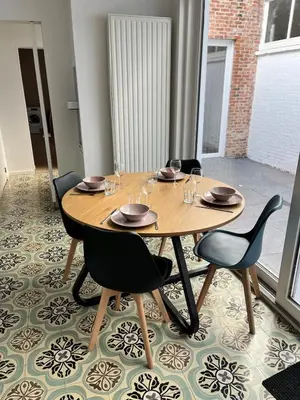 a wooden table with chairs and wine glasses on it at Temse city center in Temse