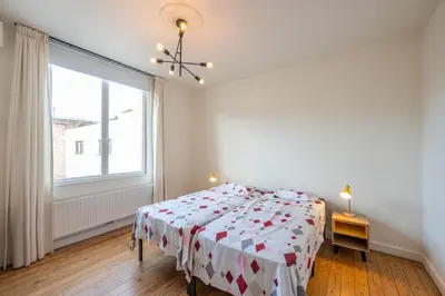 a bedroom with a bed and a large window at Temse city center in Temse