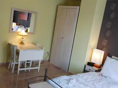a bedroom with a bed and a table and a desk at Hotel Golden Dragon in Dessel