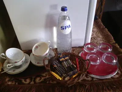 a bottle of water sitting next to cups and a basket at Hotel Golden Dragon in Dessel