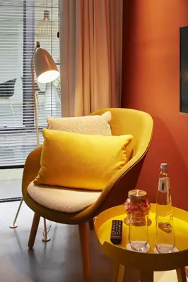 a yellow chair and a table with a bottle on it at B&B Ceder10 in Kruibeke
