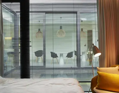 a room with a bed and a window with chairs at B&B Ceder10 in Kruibeke