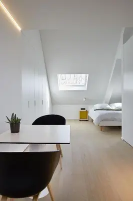 a white bedroom with a bed and a white table at B&B Ceder10 in Kruibeke