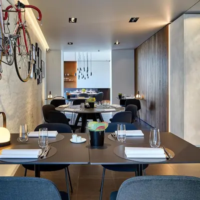 a restaurant with tables and chairs and a bike on the wall at B&B Ceder10 in Kruibeke