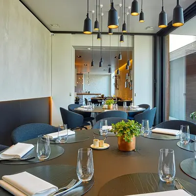 a dining room with tables and chairs and lights at B&B Ceder10 in Kruibeke