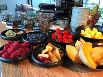 a table topped with bowls of fruit on a table at B&B Ceder10 in Kruibeke