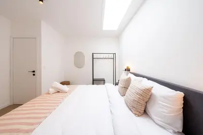 a bedroom with a large white bed with pillows at Spacious City Getaway for 8 in Antwerp in Antwerp