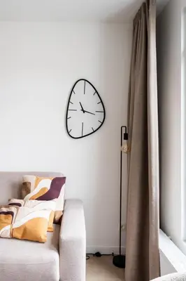 a living room with a clock on the wall at Spacious City Getaway for 8 in Antwerp in Antwerp