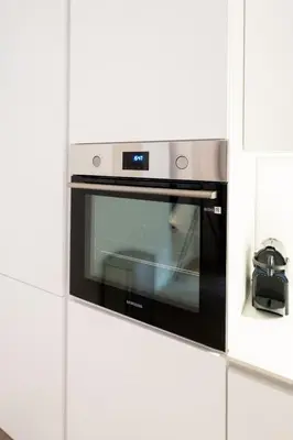 a microwave oven in a white tiled kitchen at Spacious City Getaway for 8 in Antwerp in Antwerp