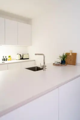 a kitchen with white cabinets and a sink at Spacious City Getaway for 8 in Antwerp in Antwerp