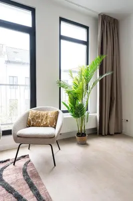 a living room with a chair and a plant at Spacious City Getaway for 8 in Antwerp in Antwerp