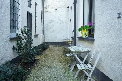 a patio with two chairs and a table and a window at Charming home by Grote Markt with Free Parking in Antwerp