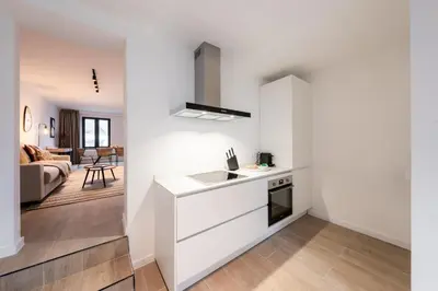 a white kitchen with a sink and a stove at Inviting 5-Person Duplex in Vibrant Antwerp in Antwerp
