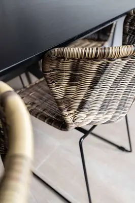 a wicker chair sitting under a black table at Inviting 5-Person Duplex in Vibrant Antwerp in Antwerp