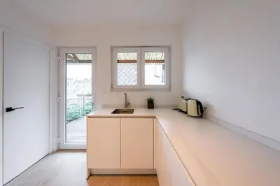 a white kitchen with a sink and a window at Inviting 5-Person Duplex in Vibrant Antwerp in Antwerp