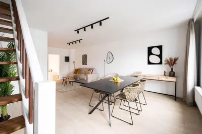 a dining room and living room with a table and chairs at Inviting 5-Person Duplex in Vibrant Antwerp in Antwerp