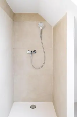 a shower with a shower head in a bathroom at Inviting 5-Person Duplex in Vibrant Antwerp in Antwerp