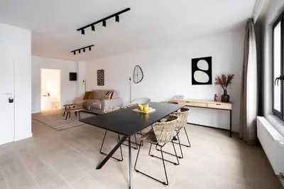 a dining room and living room with a table and chairs at Inviting 5-Person Duplex in Vibrant Antwerp in Antwerp