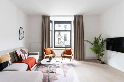 a living room with a couch and a tv at Inviting and bright 7-Person Apartment in Antwerp in Antwerp