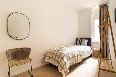 a bedroom with a bed and a mirror and a chair at Inviting and bright 7-Person Apartment in Antwerp in Antwerp