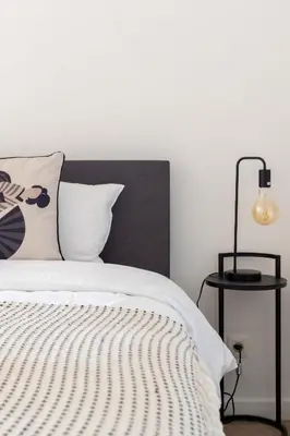 a white bed with a black headboard and a lamp at Inviting and bright 7-Person Apartment in Antwerp in Antwerp