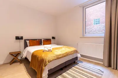 a bedroom with a bed and a large window at Inviting and bright 7-Person Apartment in Antwerp in Antwerp