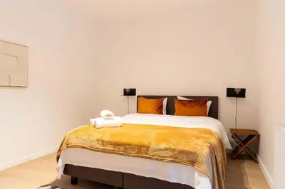 a bedroom with a large bed with orange pillows at Inviting and bright 7-Person Apartment in Antwerp in Antwerp